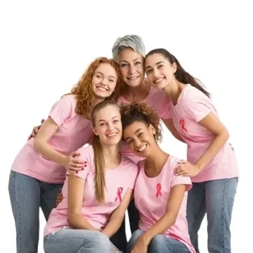 Women in pink shirts embracing and smiling.